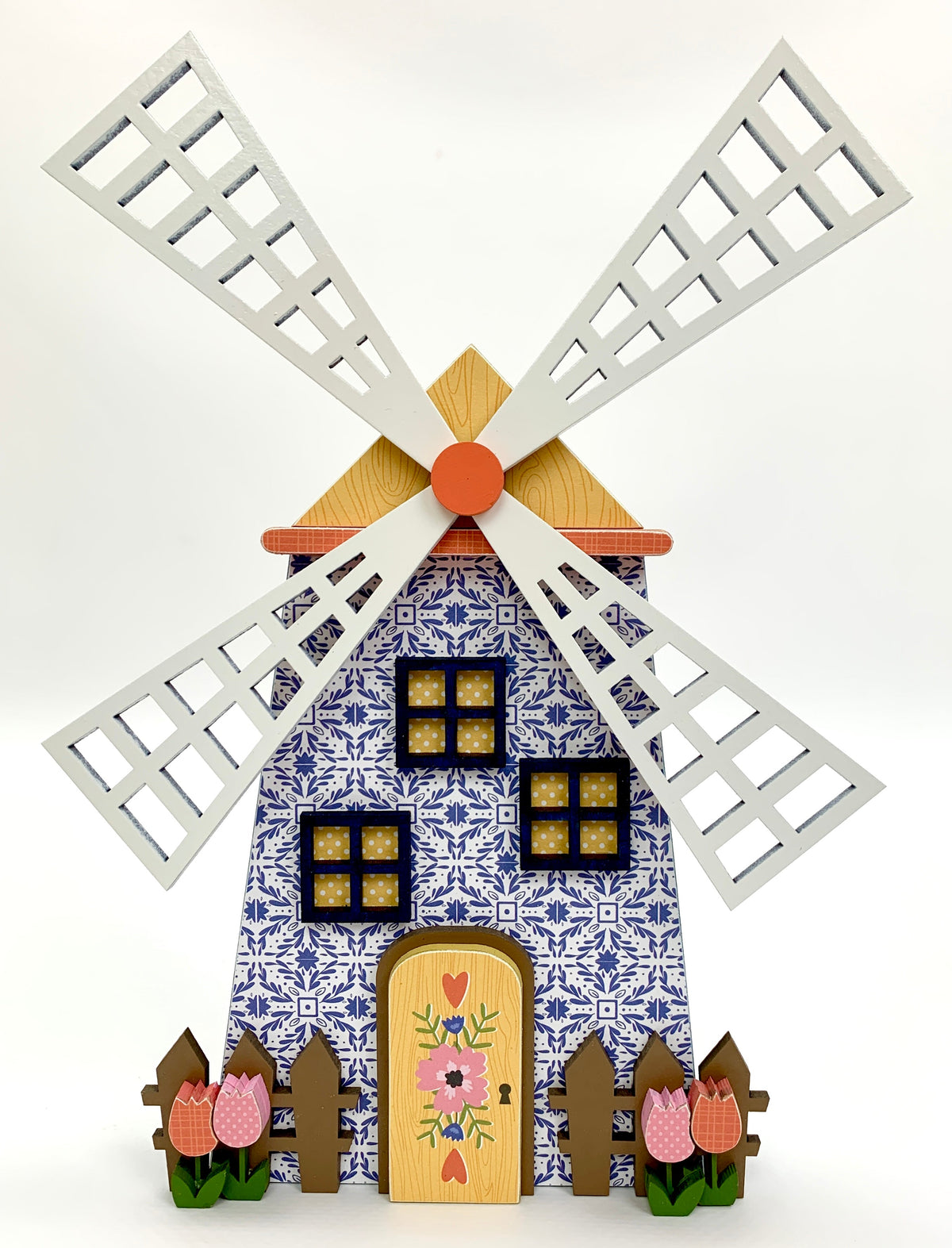 Blue delft dutch wood windmill with picket fence and tulips.