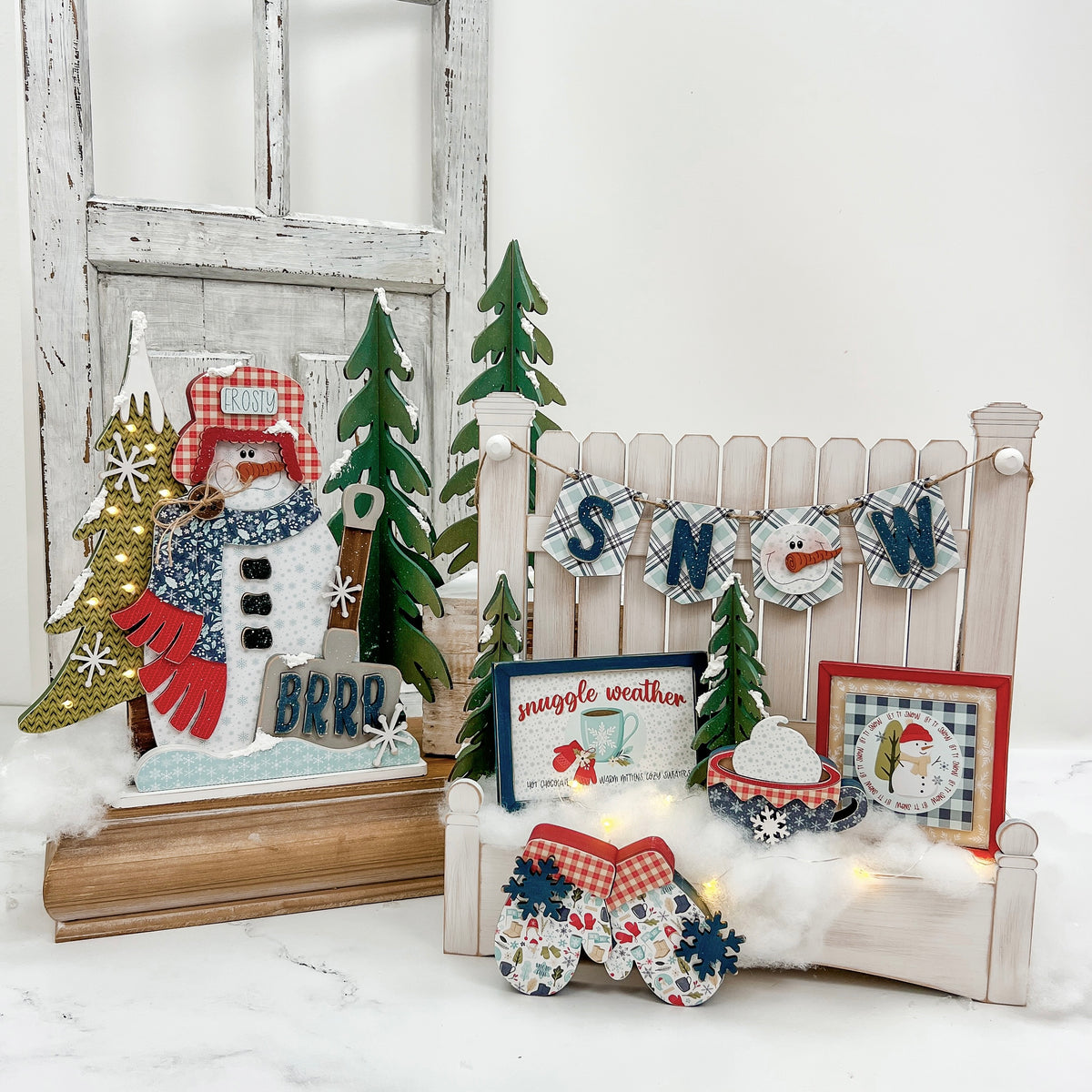 Decorative DIY wood decor kit with winter scene with snowman, trees, and signs on a white background