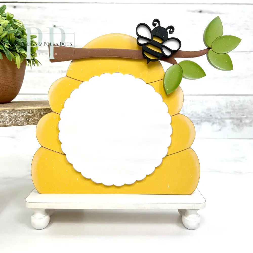 Yellow bee hive with a branch and honey bee for displaying a finished cross stitch