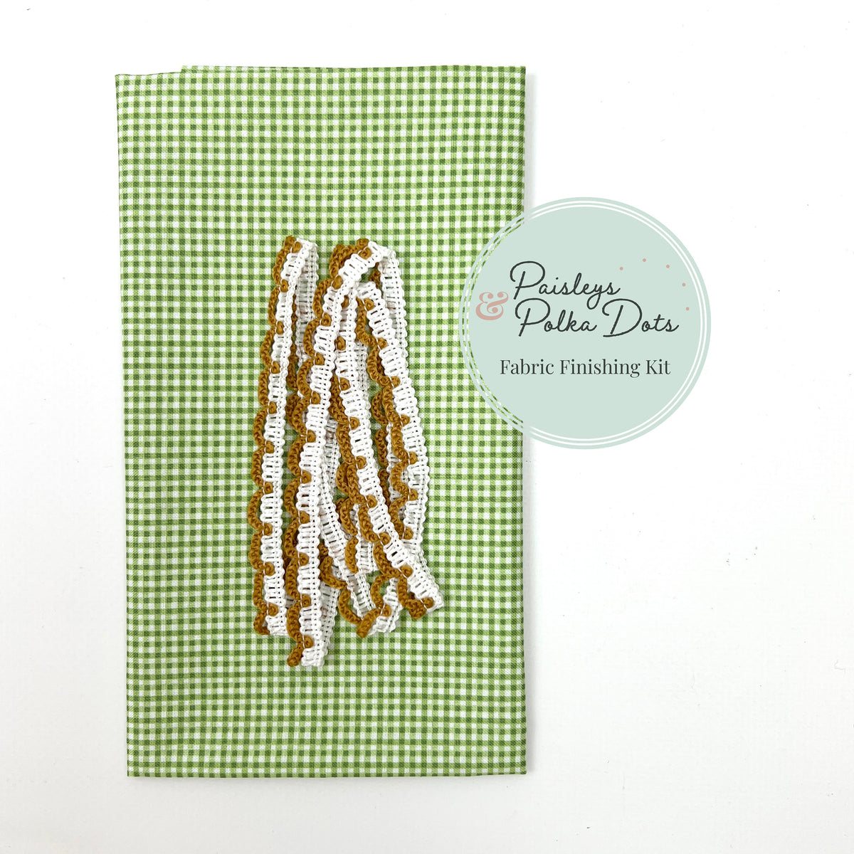 Fabric finishing kit with lace trim on a green gingham checkered background.