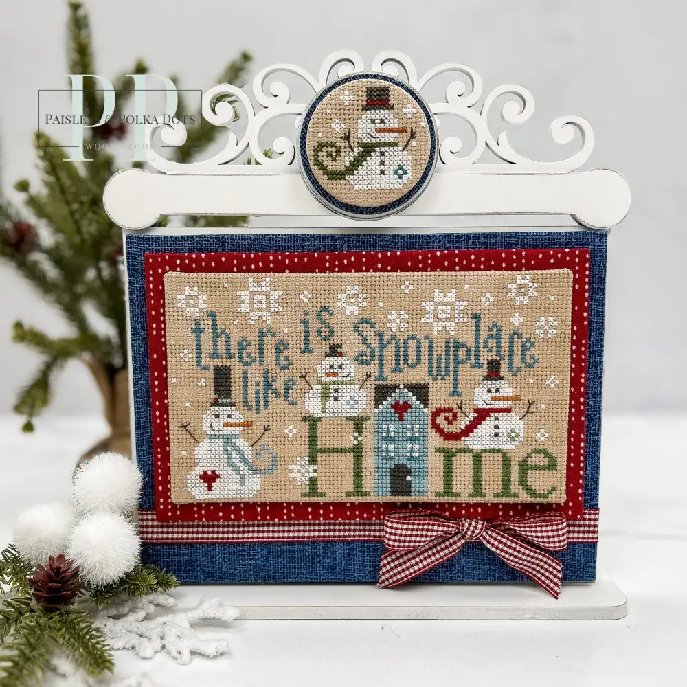 Cross stitch display with a scroll work top with a finished cross stitch Snowplace like home from Primrose Cottage