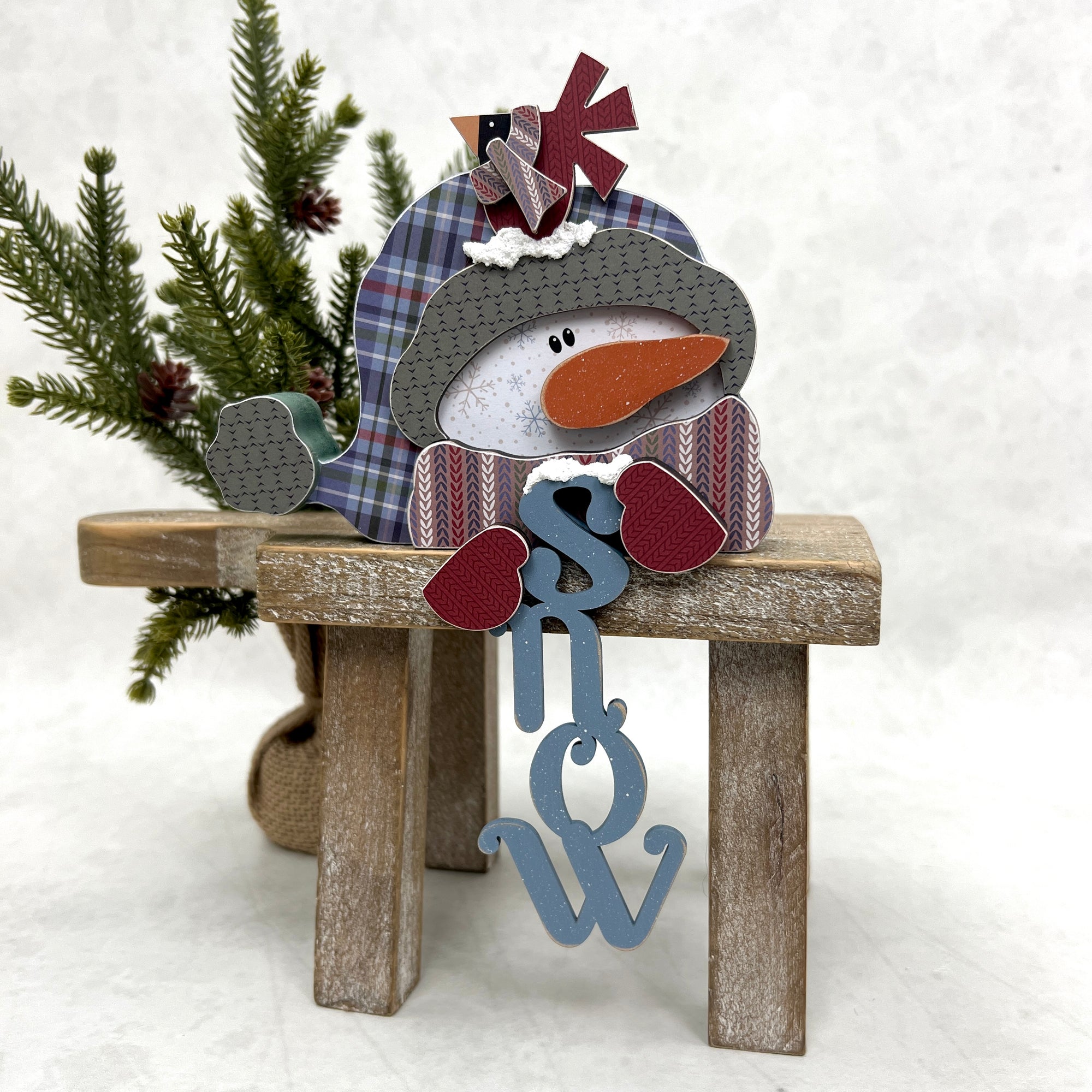 Wood decor snowman holding the word snow in his hands. Winter wood craft kit for tiered trays, table tops, and shelf sitters.