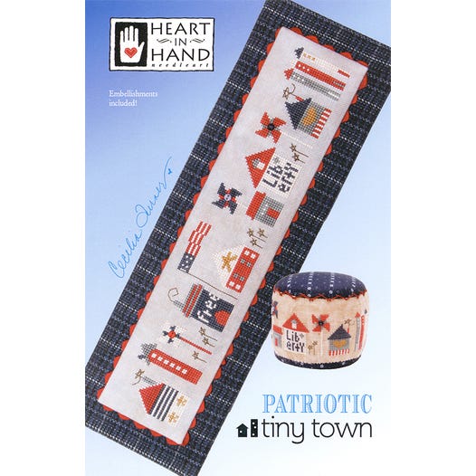 Cross-stitched pattern of a patriotic village celebrating the 4th of July with 'Heart in Hand' branding 
