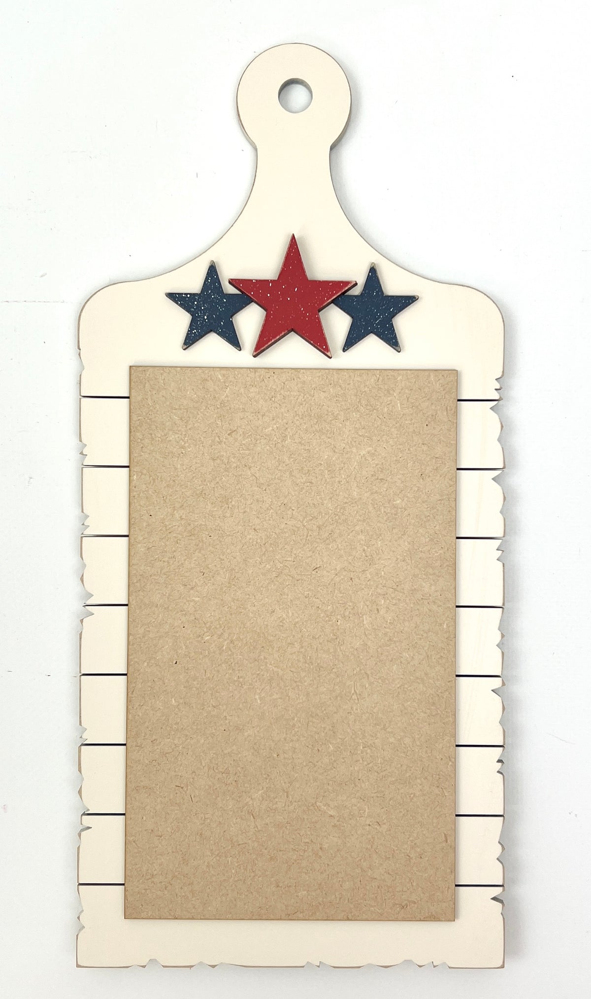 Pre-painted cream patriotic cross stitch display with red and blue wooden stars, holding an Americana cross stitch piece with red and blue fabric accents.