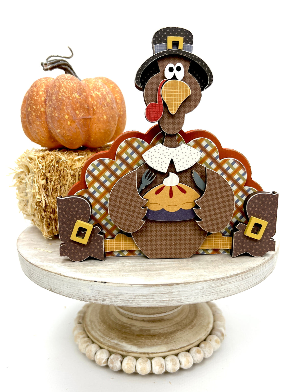 Sitting turkey eating pie decoration on a white pedestal stand