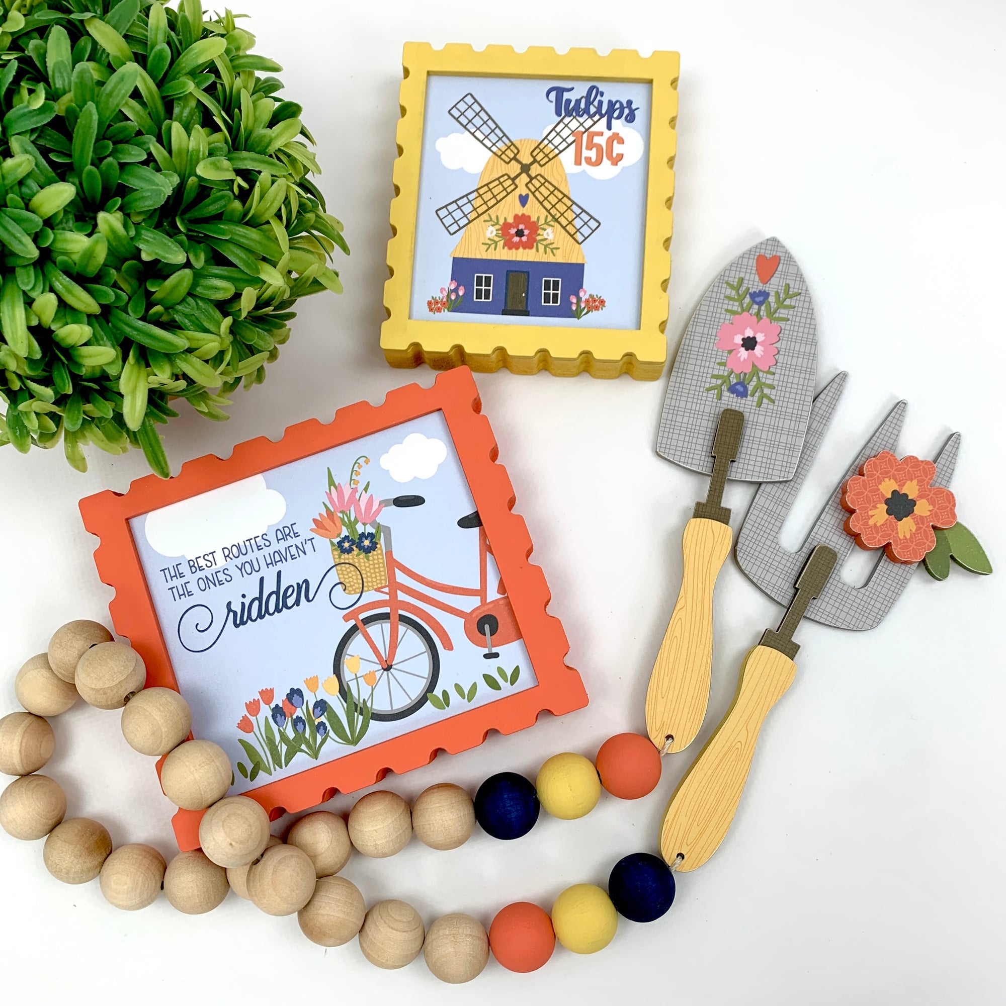 Spring teired tray signs with windmill, bicycle, and a beaded garland with gardening tools. 