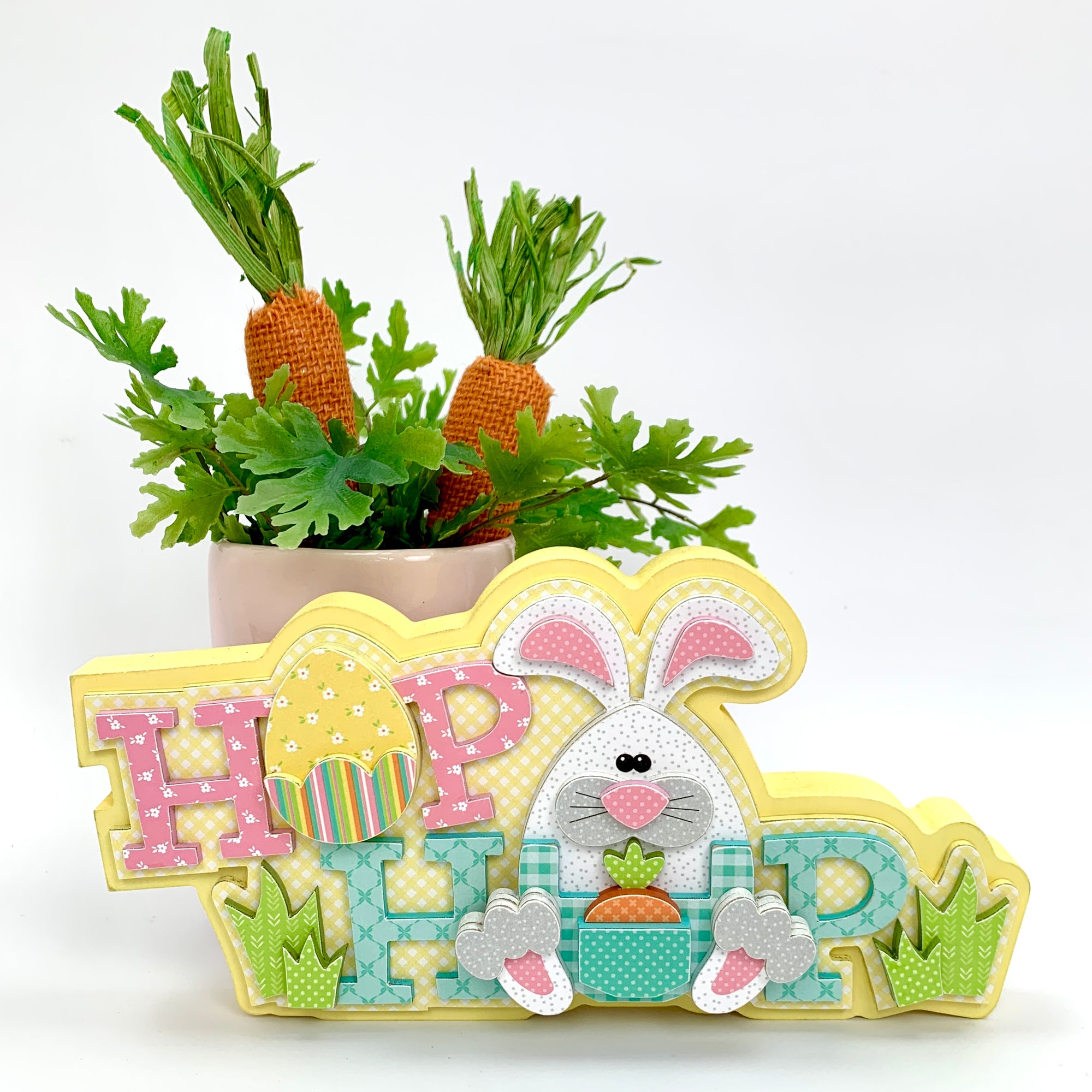 Easter wood decoration with Hop words, a white and pink bunny, and yellow easter egg. 