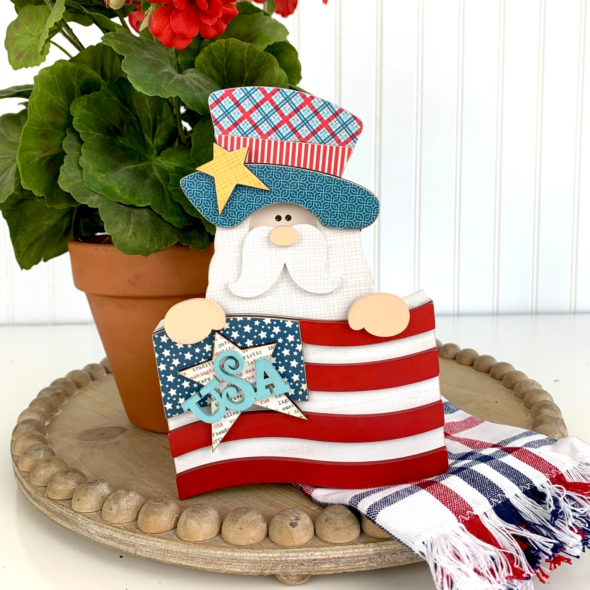 Patriotic or 4th of July uncle sam holding an american flag with a star and USA word wood decoration sitting on a wood tray 